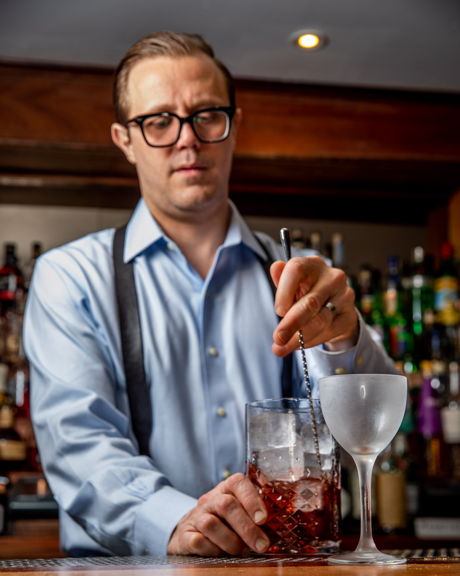 A bartender stiring a drink in a bar