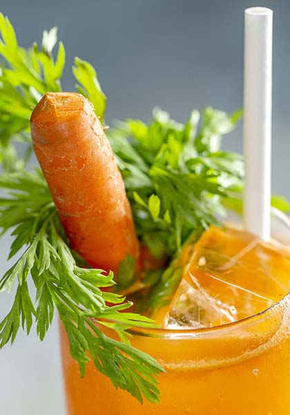 Healthy cocktail with a carrot sticking out of it photographed at Happiest Hour in Manhattan.