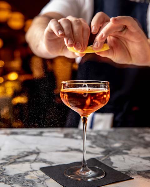 Bartender squeezing a lemon at Oceans NY. 