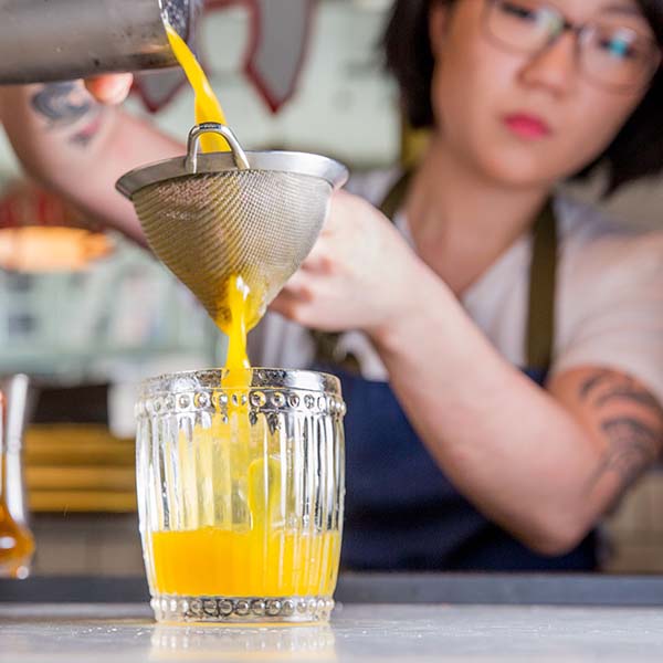 Jane pouring a drink at Shuka.