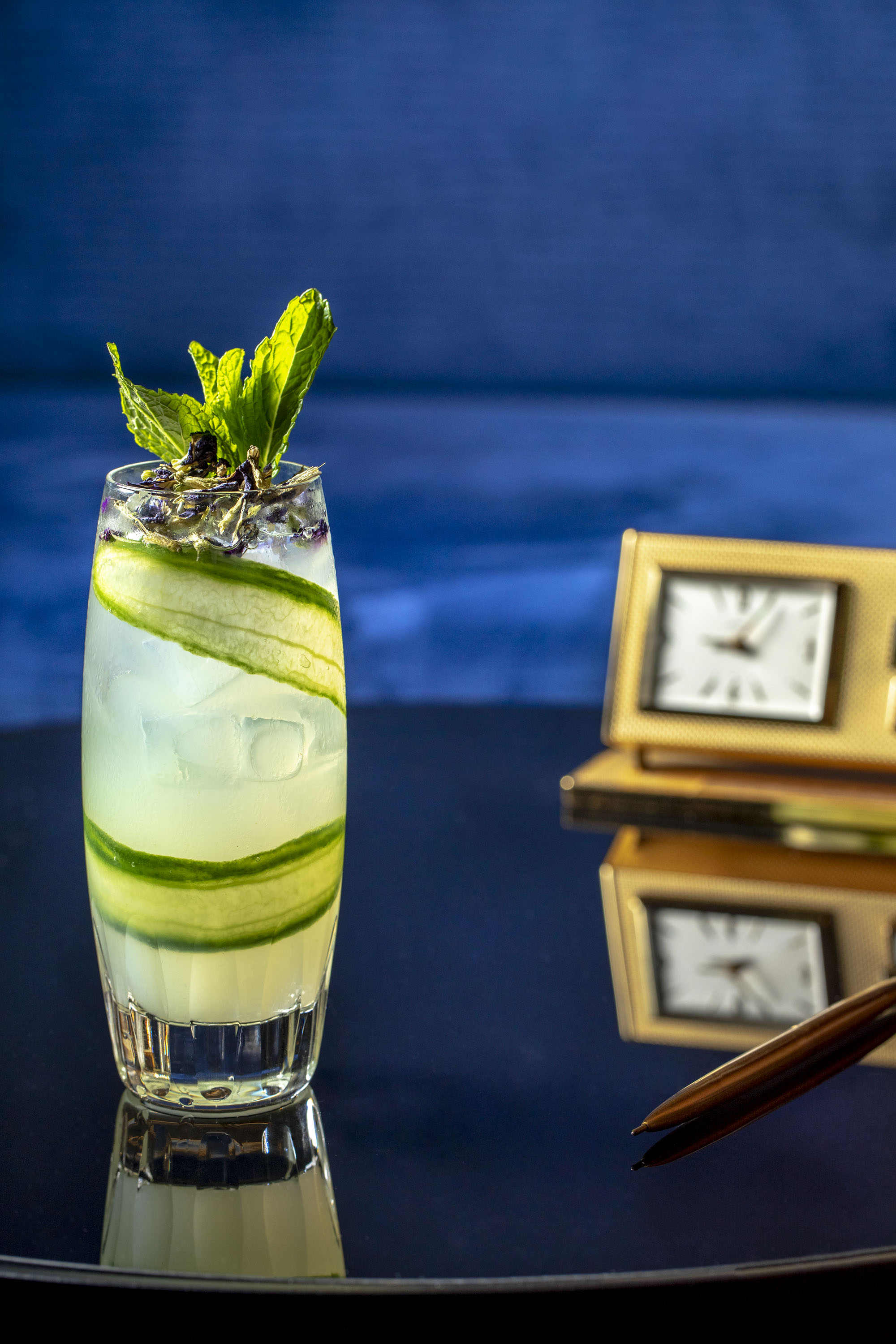 sophisticarted cucumber cocktail in a blue setting