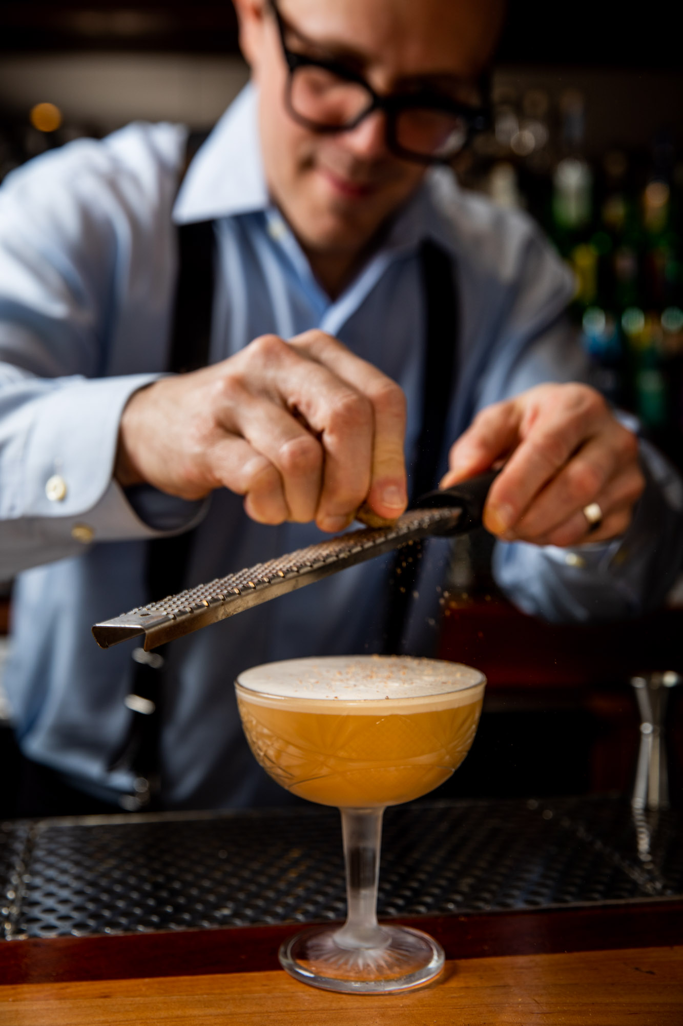 A bartender gratting cinnamom