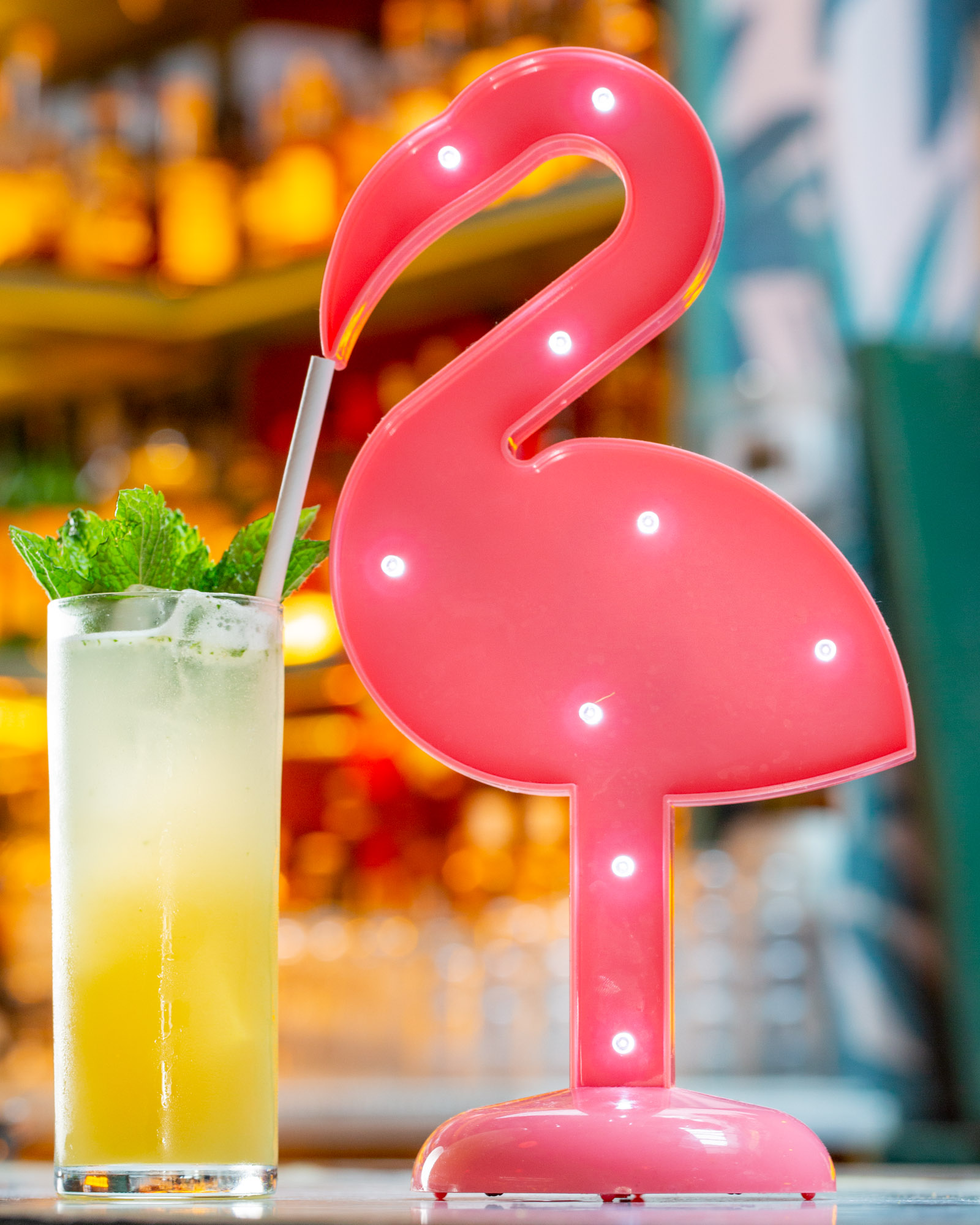 A flamingo drinking a tropical cocktail.